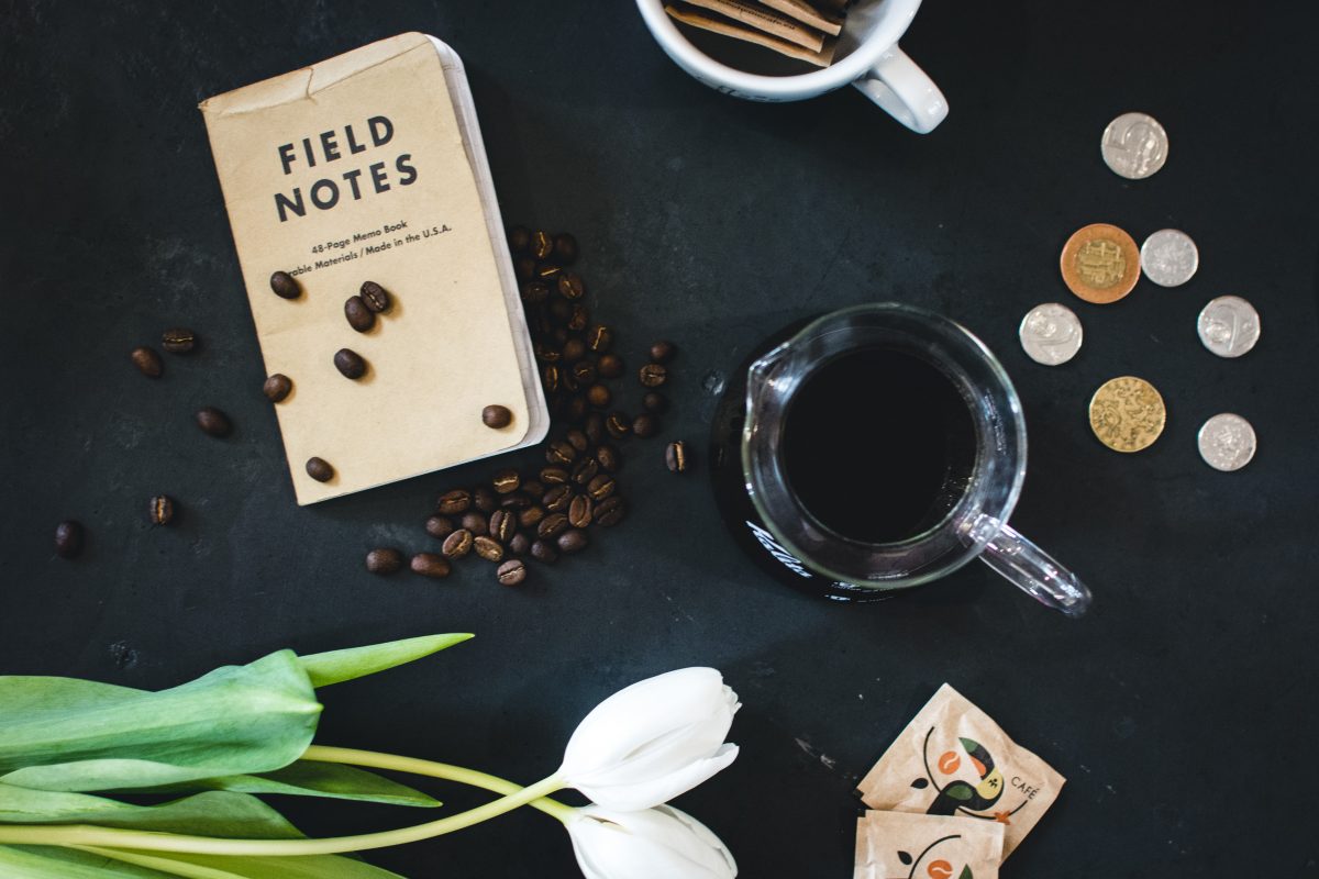 Coffee with field notes and coins